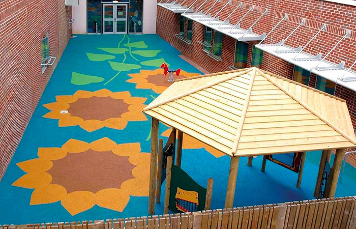 playground flooring safety surface installed in a court yard with flower graphics