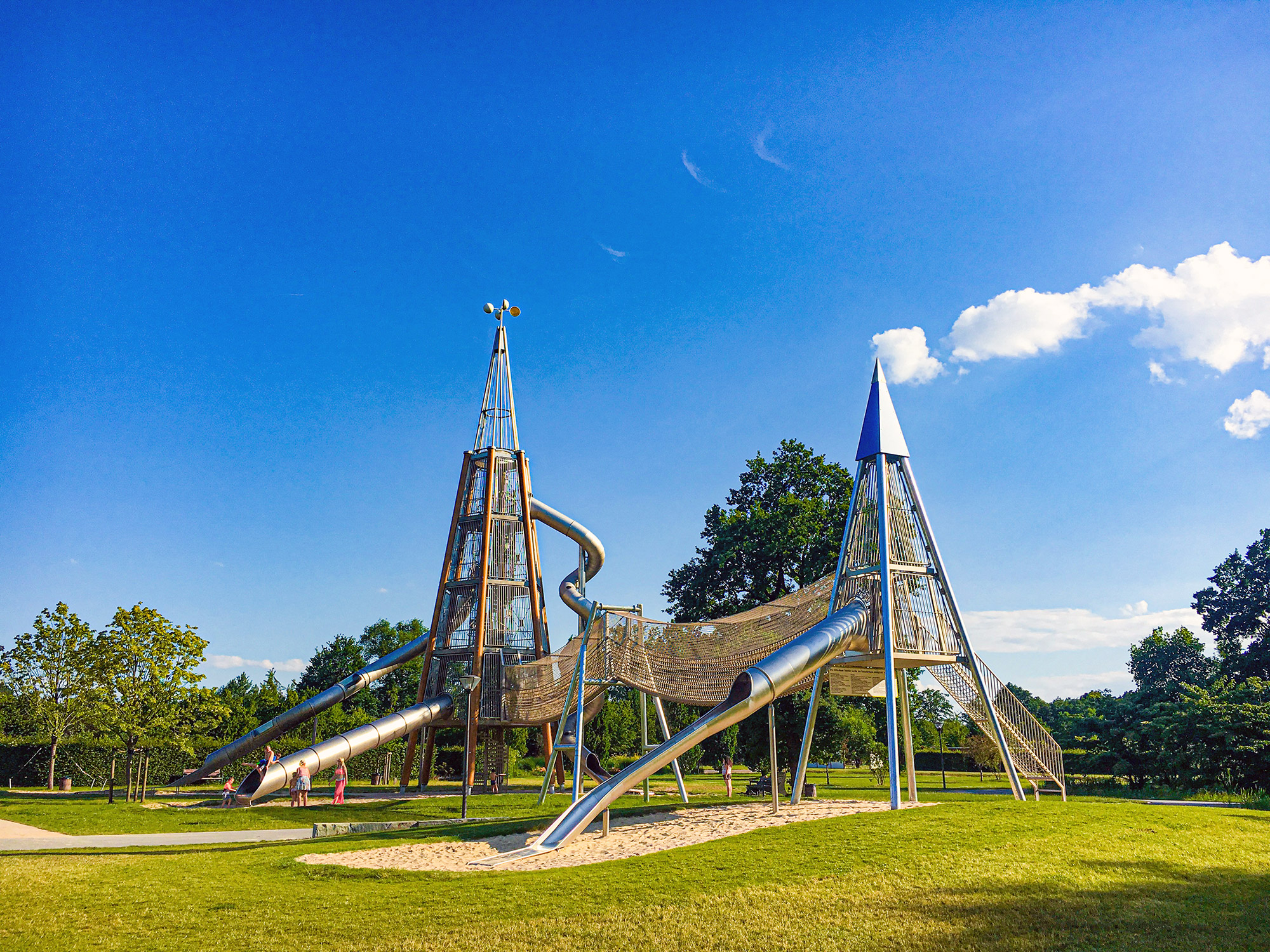 large tower playground equipment with multiple slides and nets