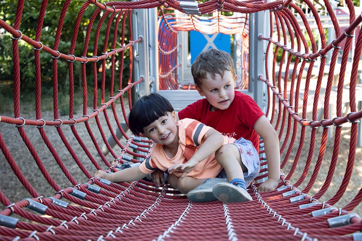 Children enjoying a vibrant community playground rope bridge
