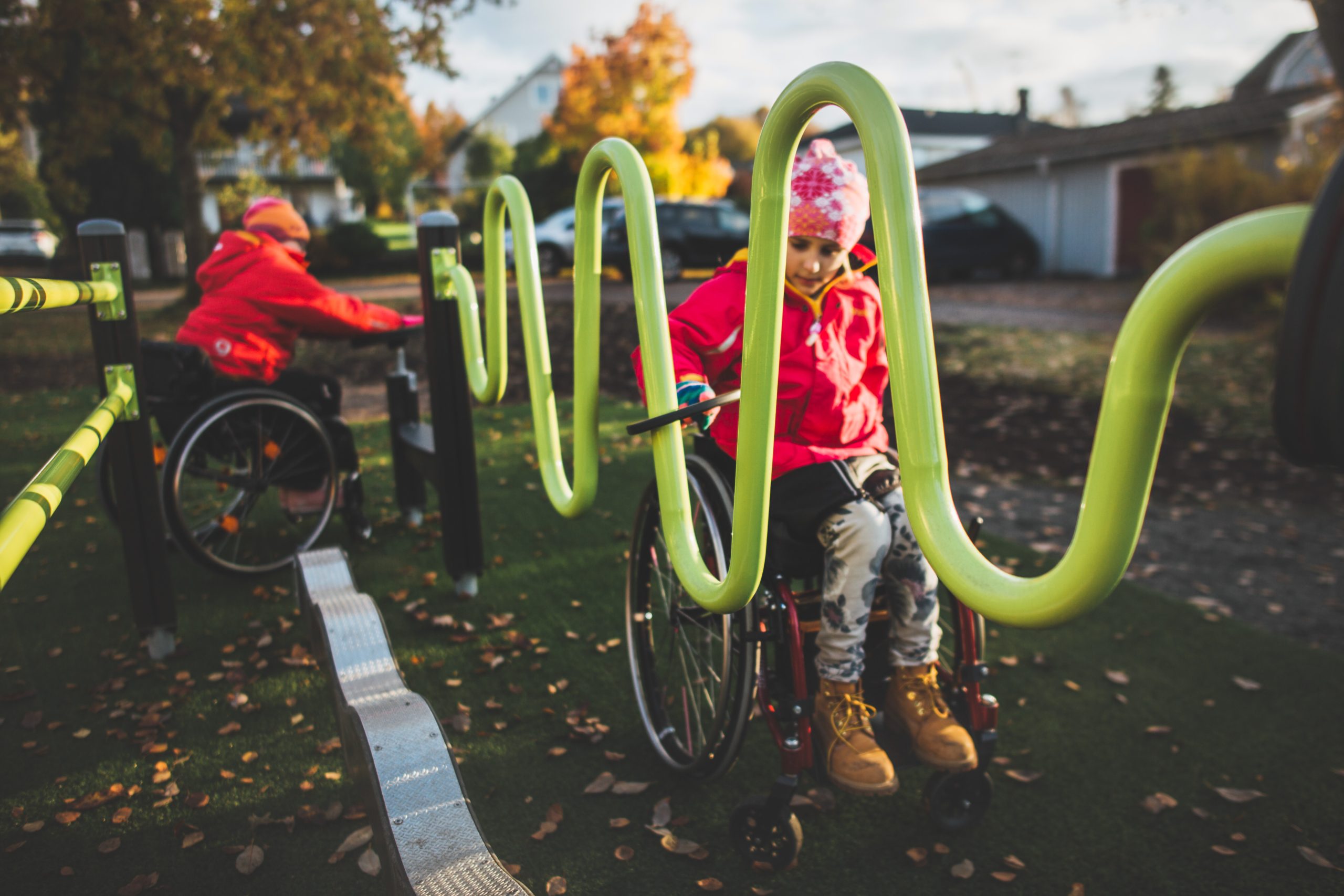 inclusive playground in community being used by 2 children in wheel chairs